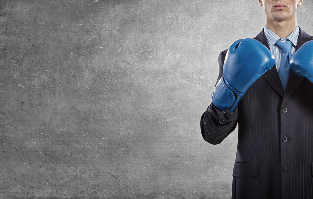 Determined businessman in suit and boxing gloves